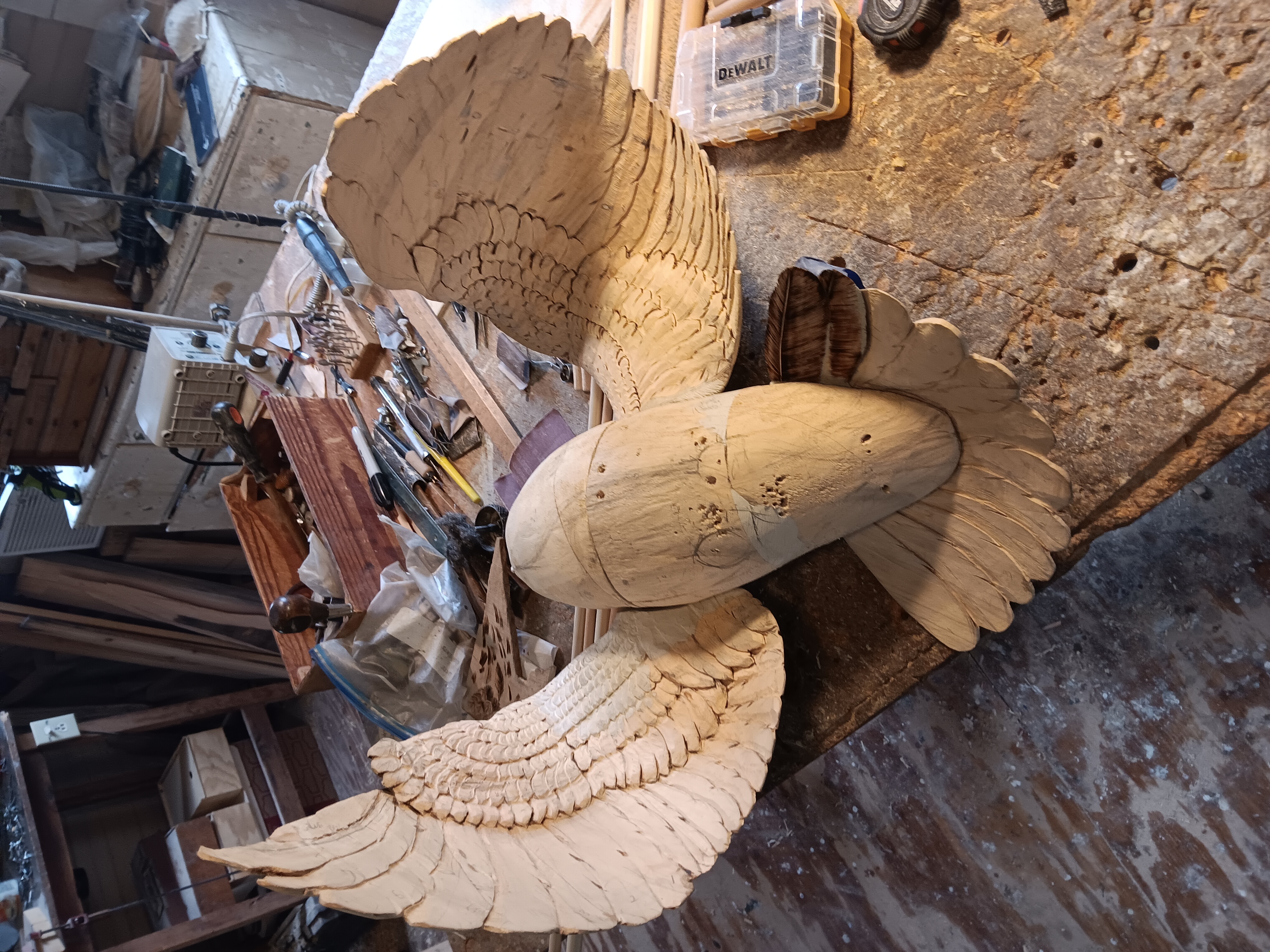 Large bird sculpture showing detailed feather carving in progress